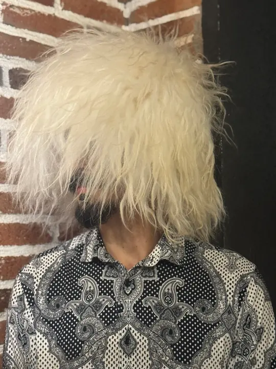 White sheepskin papakha with long straight wool, worn by a man, three-quarter view